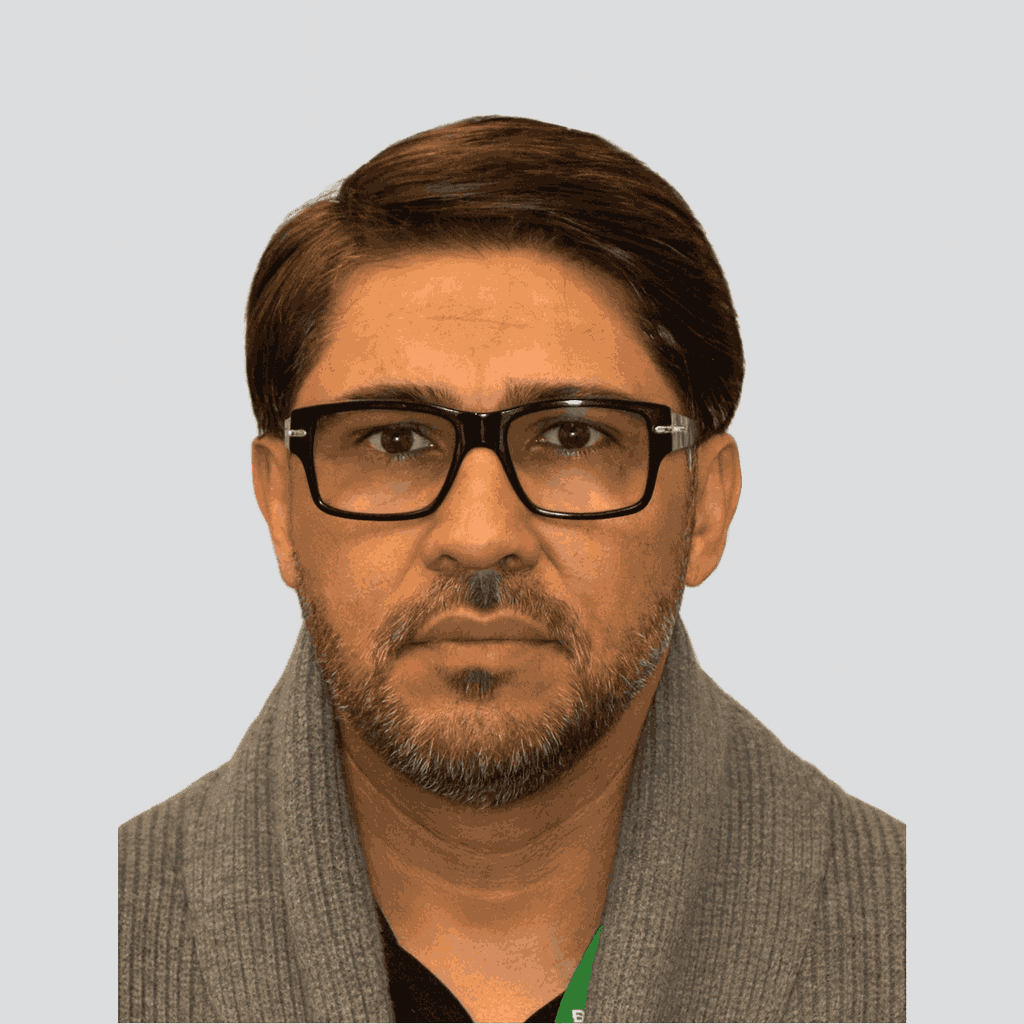 Portrait of a Cerberus Security team member wearing glasses and a grey sweater, facing forward.